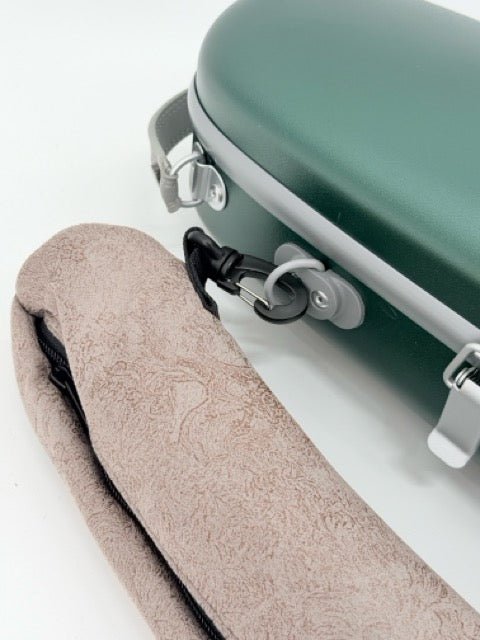 The Artino Muse CN3804 Violin Case, featuring a green polycarbonate hard shell with silver hardware, sits beside a beige textured soft case, both fastened together by a black plastic clip.