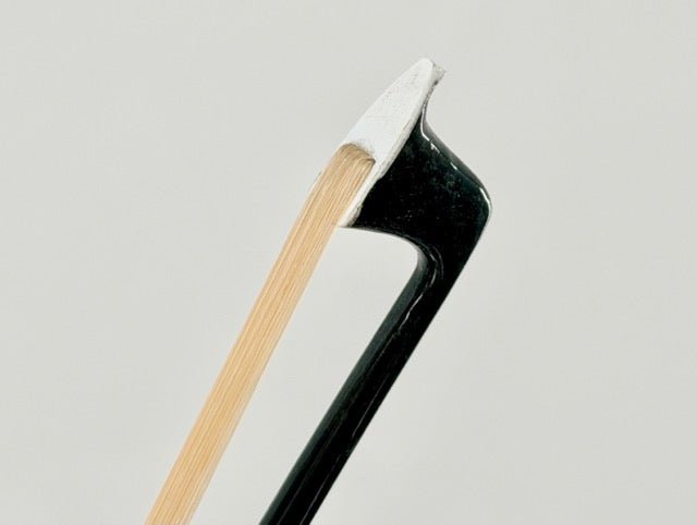 Close-up of the Atelier Braided Carbon Fiber Bow tip, featuring white Mongolian horsehair and a black carbon fiber stick against a plain, light gray background.
