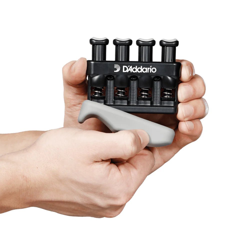 A person uses the D’Addario Varigrip Finger Exerciser for String Players, pressing buttons with one hand and gripping its ergonomic base with the other to build hand strength—perfect for string musicians.