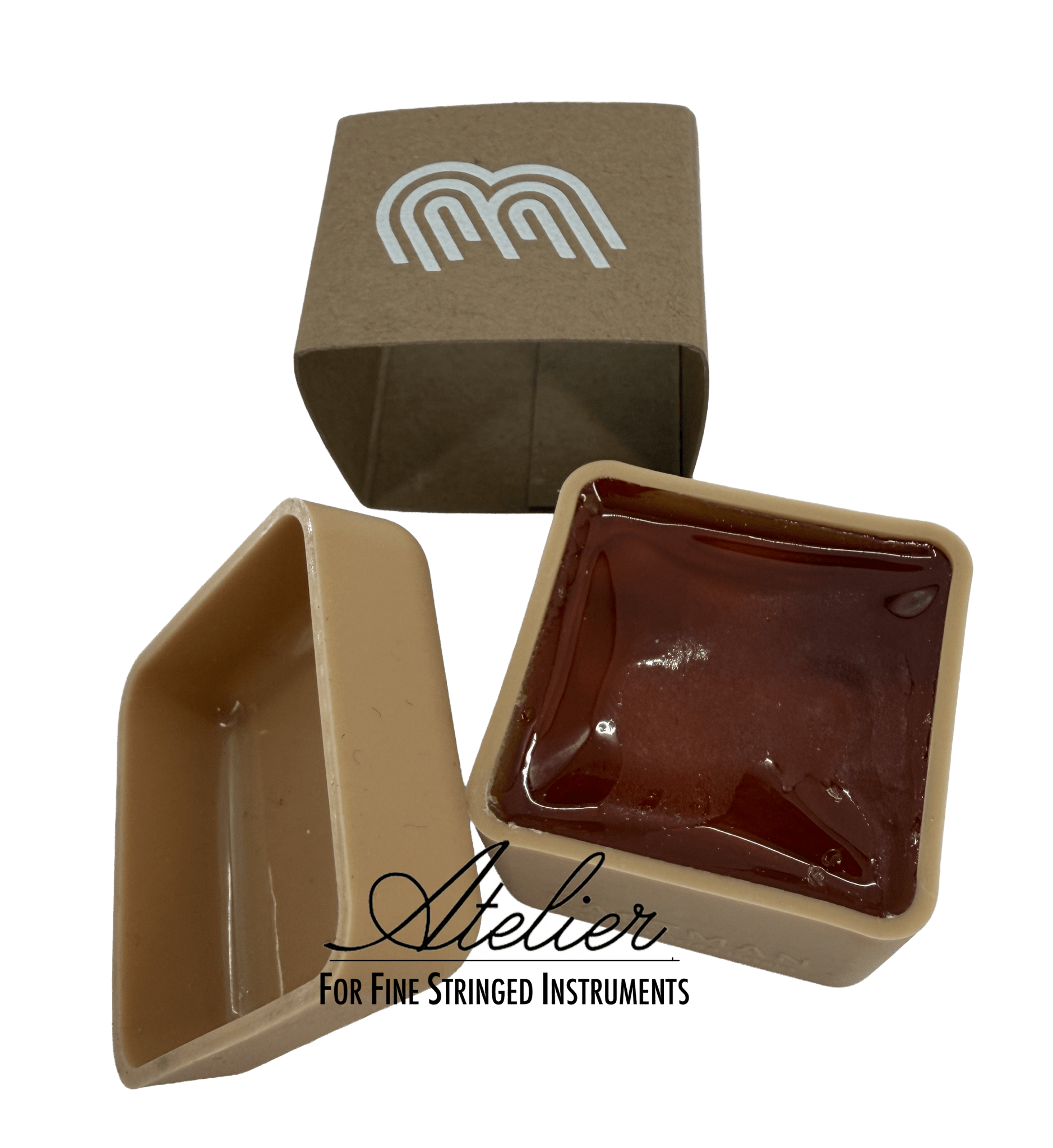 A square container of reddish-brown Eastman Bass Rosin by Leatherwood for string instruments with its beige lid beside it. A brown box with a white logo stands behind. "Atelier For Fine Stringed Instruments" appears below.