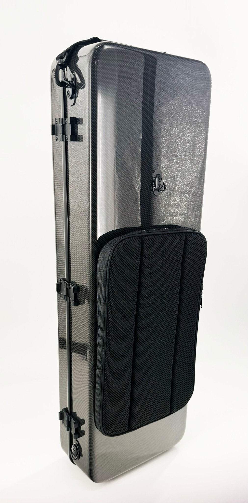 A hard-shell, rectangular, dark gray carbon fiber oblong viola case with black latches and a large, textured, zippered front pocket stands upright against a white background. This lightweight viola case offers superior protection and modern style for your instrument.