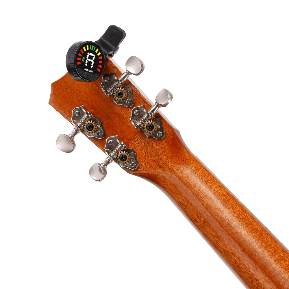 Close-up of the back of a guitar’s headstock with metal tuning pegs and a Nexxus 360 USB Rechargeable Tuner clipped on, its omnidirectional LED screen glowing. The smooth, polished wood highlights the tuner’s modern design.