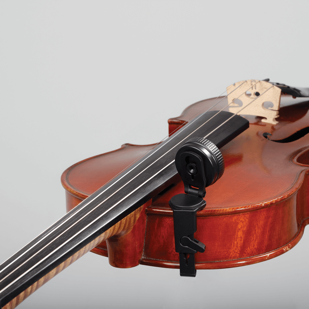 A close-up of a violin with a Nexxus 360 Violin Rechargeable Tuner clipped onto its fingerboard, against a plain light gray background.