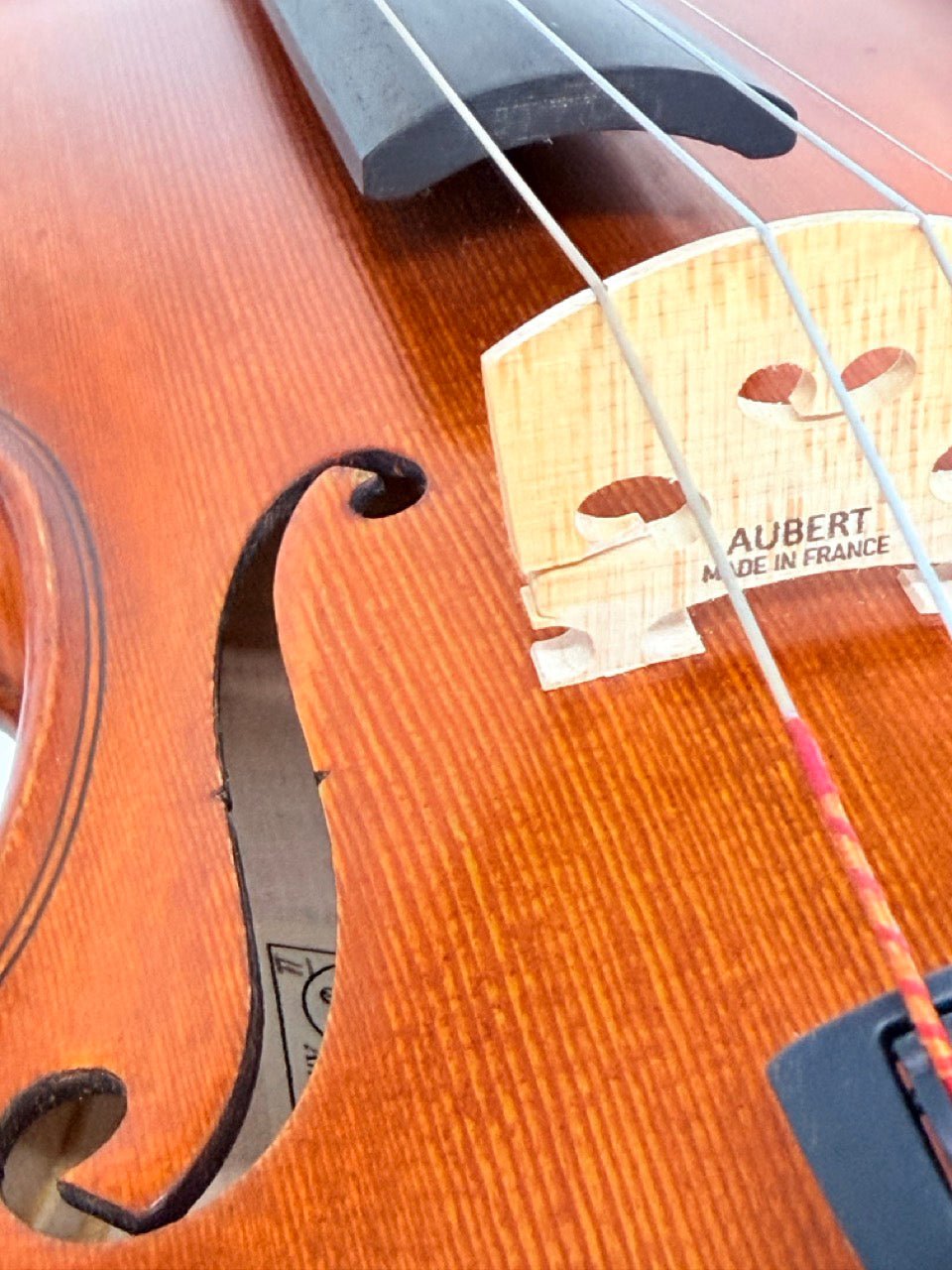 Close-up of the Octav Mures Romanian Intermediate Violin, showing its f-hole, strings, and bridge. Professionally set up by Atelier, its warm wood grain highlights the fine craftsmanship typical of quality intermediate violins.