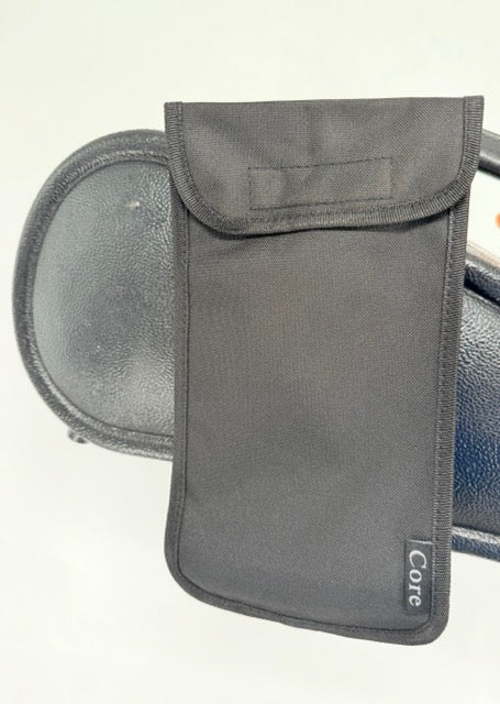 A black fabric Pouch for Shoulder Rest labeled “Core” is draped over the backrest of a black leather chair, set against a plain light background.
