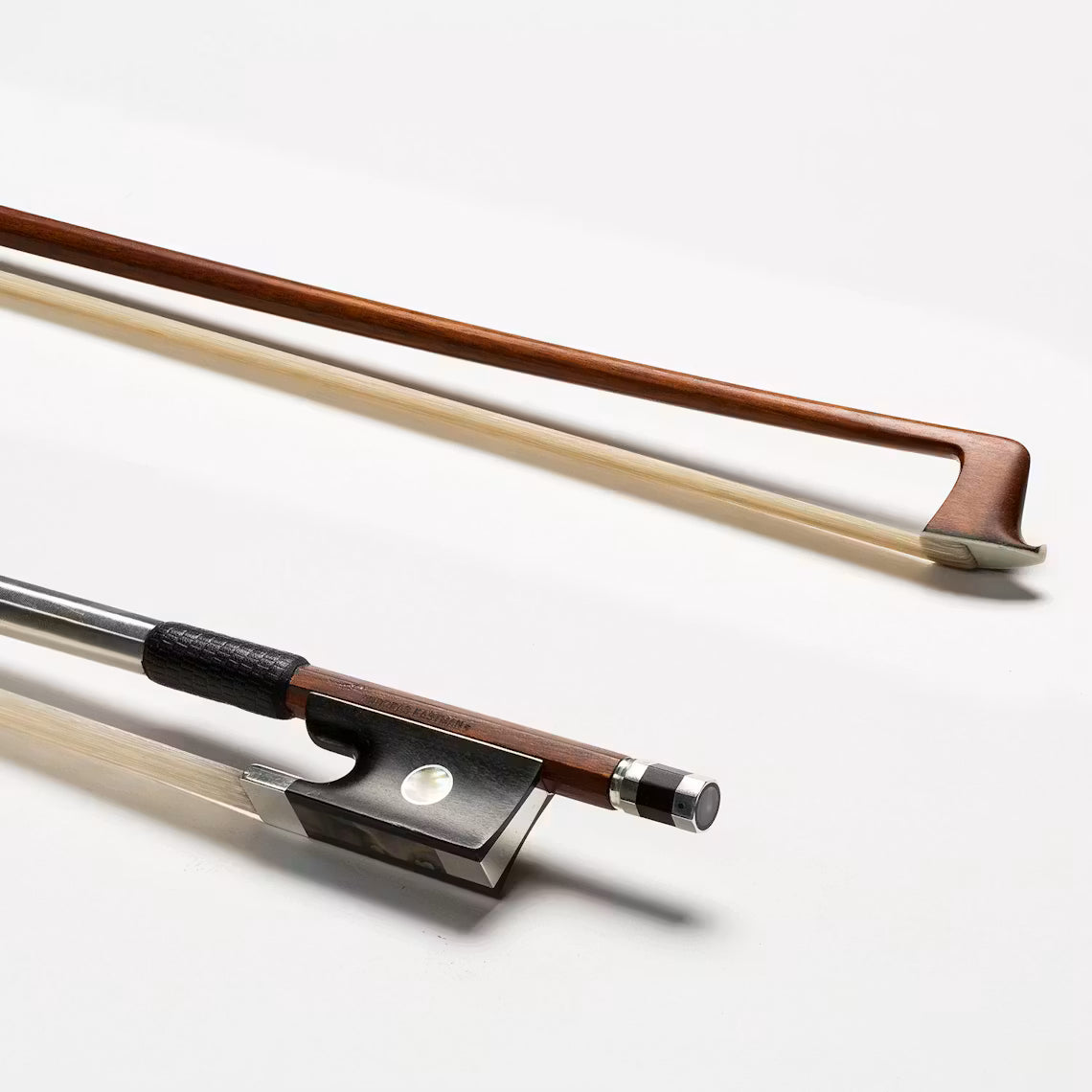 Two Andreas Eastman BL90 One Star Pernambuco 4/4 violin bows are arranged diagonally on a white background—one displays the full length, while the other focuses on the frog, screw, and grip for advancing players seeking quality wood and metal details.