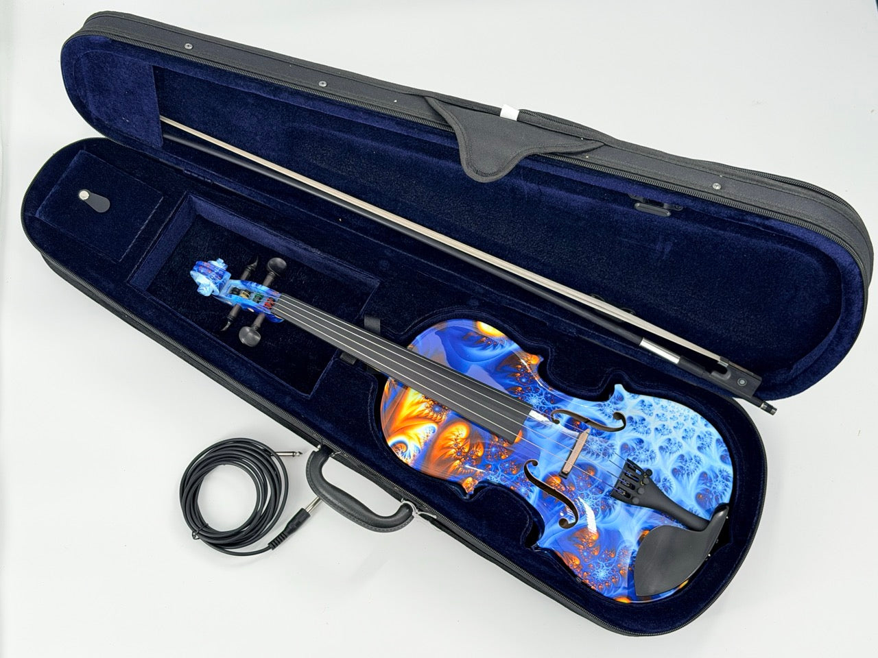The Geneva Acoustic / Electric Violin, showcasing a vibrant blue and orange swirling design, rests in a dark blue velvet case with an upgraded bow placed above it and a coiled audio cable beside the case for professional setup.
