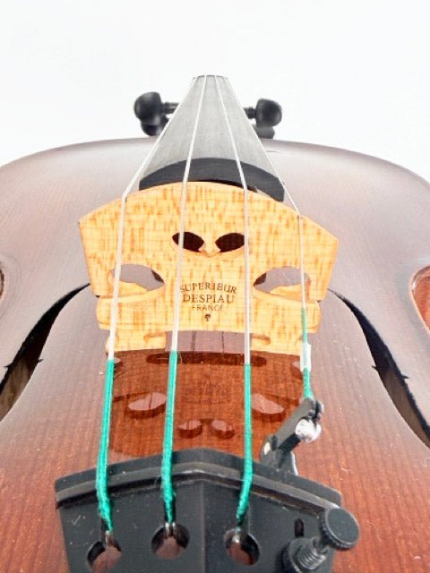 Close-up of a violin bridge with strings, highlighting the wood grain and the Superieur Despiau France label on the bridge, with the body of an Andreas Eastman VA305 Stradivari Viola in the background.