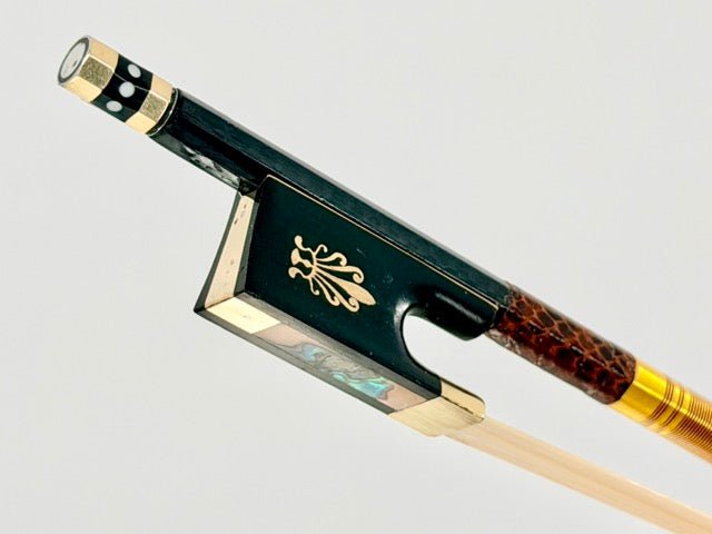 Close-up of the Atelier Braided Carbon Fiber Bow’s frog, showcasing ornate gold detailing, mother-of-pearl inlay, black and gold design with a patterned grip, Mongolian horsehair, and exceptional craftsmanship.