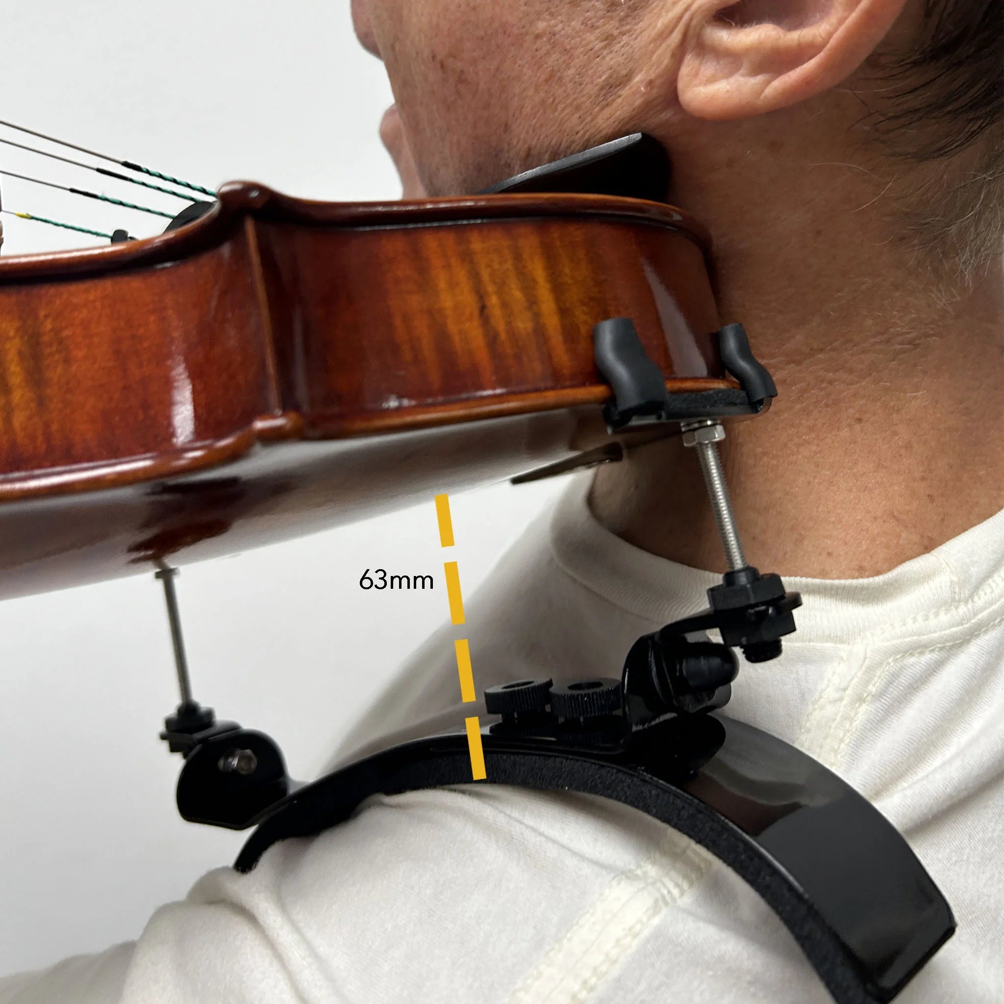 A person holds a violin on their shoulder using the Bonmusica Violin Shoulder Rest. A yellow dashed line marked 63 mm shows the measured distance between the shoulder rest and the violin.