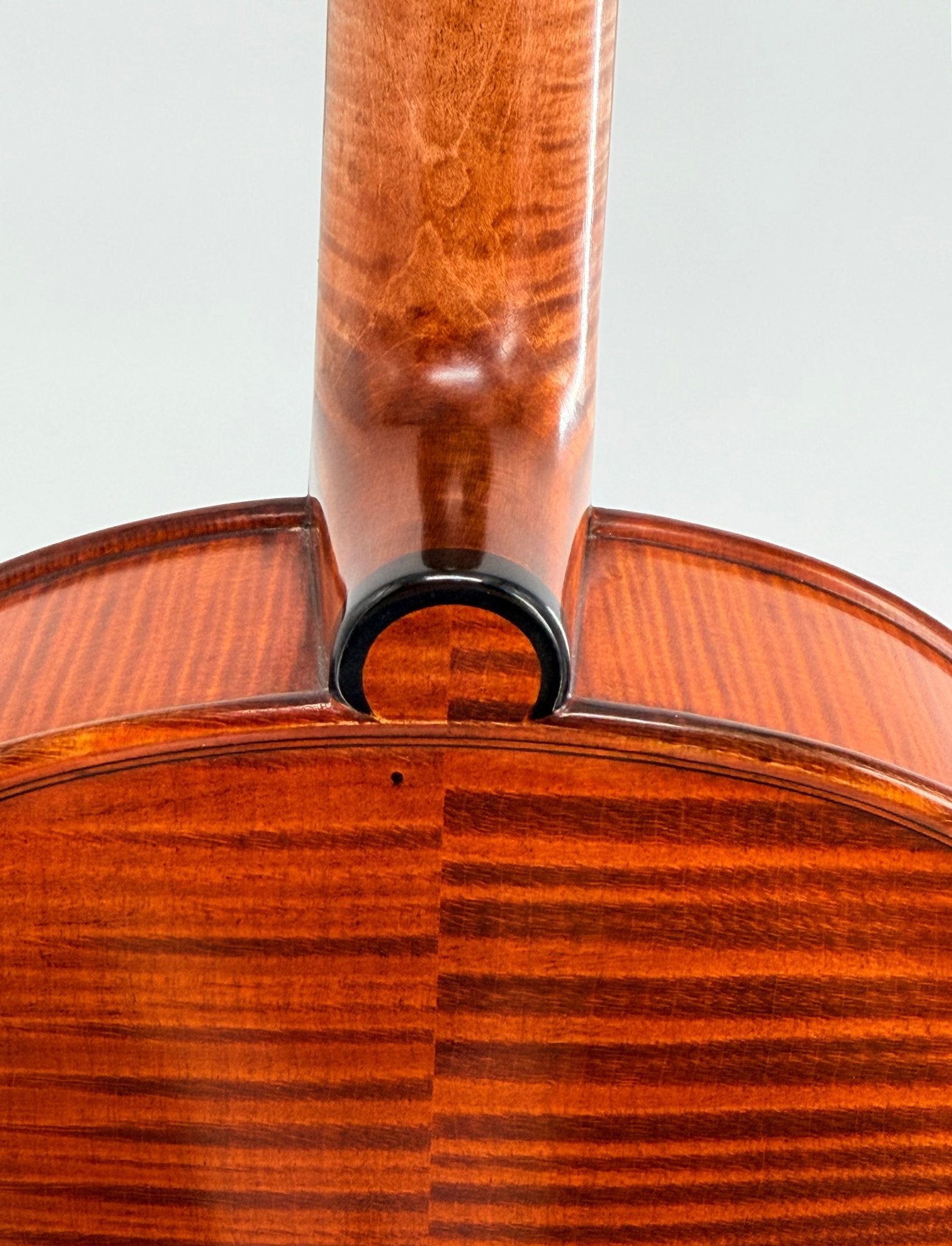 Close-up of the neck joint on the Canzona Maestro-Level Viola – New Old Stock, Romanian made, crafted from flamed maple and bear claw spruce with polished reddish-brown finish and striking grain patterns.