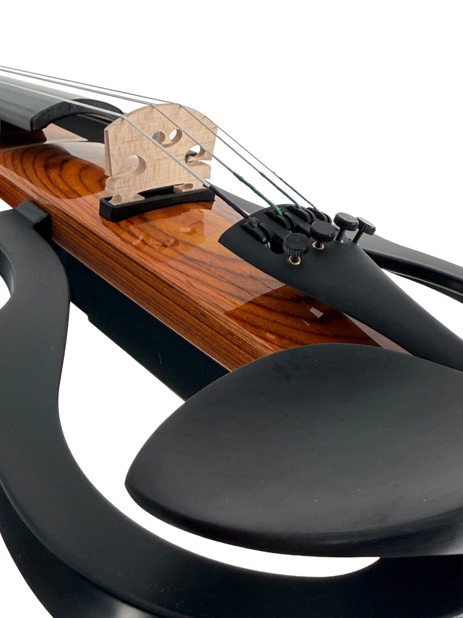 Close-up of the Geneva Electric Violin – Professionally Set Up at Atelier, showing its strings, wooden bridge, curved black body, and chin rest—showcasing a modern design and mixed materials for silent practice or performance.