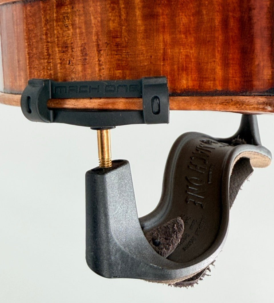 Close-up of a violin’s underside shows the Mach One MLS Shoulder Rest with Leather Strap (Plastic), a lightweight 4/4–3/4 violin support featuring padding and secure gold screw fitting.