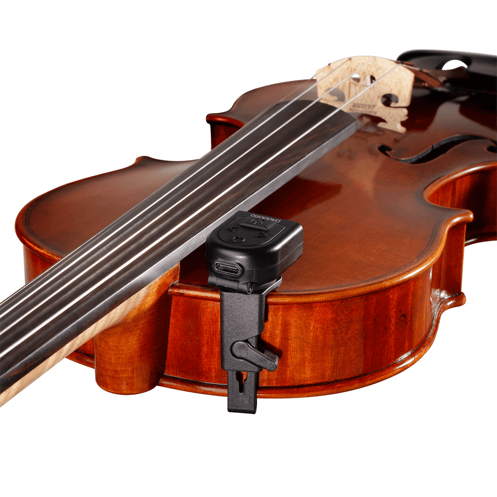 A close-up of a brown violin with the Micro Rechargeable Violin Tuner, a black clip-on tuner, attached to its side near the strings and fingerboard, set against a plain white background.