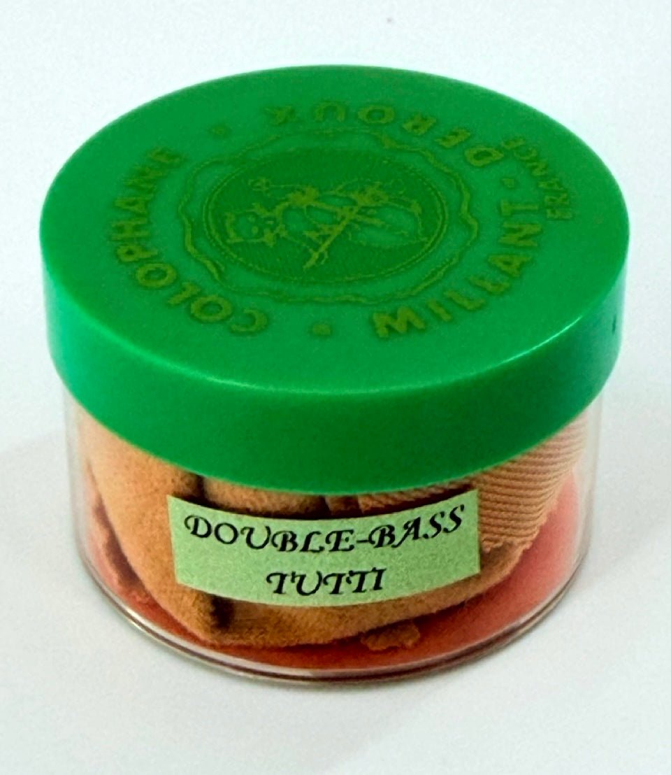 A small clear container with a green lid, labeled Millant-Deroux “Tutti” Double Bass Rosin, holds a light brown cloth—likely intended for cleaning or maintaining the rosin or other double bass accessories.