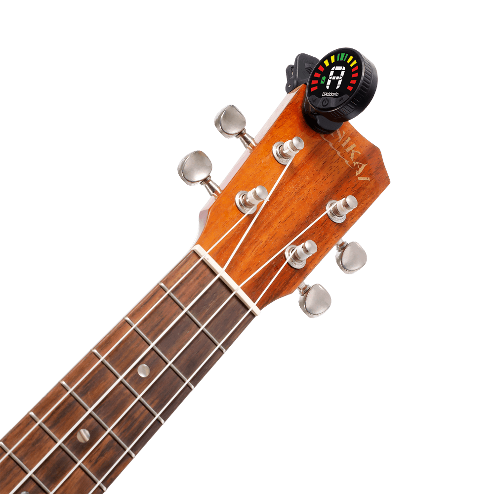 Close-up of a guitar headstock with six tuning pegs and a Nexxus 360 USB Rechargeable Tuner clipped on, its omnidirectional LED screen showing tuning info with colored bars.