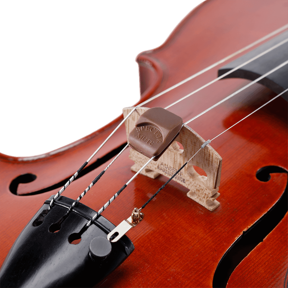 Close-up of a violin showing its bridge, strings, and a Spector Violin Mute attached to the bridge, with the wood grain of the violin’s body visible in the background.